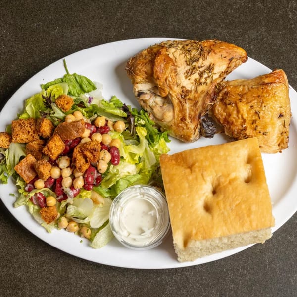 Roasted chicken with rosemary, a side salad with chickpeas and croutons, focaccia bread, and dressing.