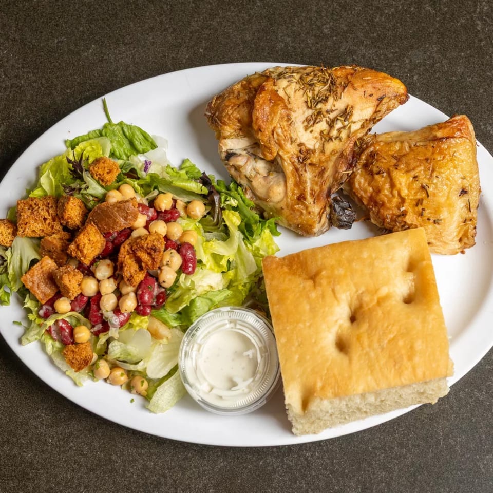 Roasted chicken with rosemary, a side salad with chickpeas and croutons, focaccia bread, and dressing.